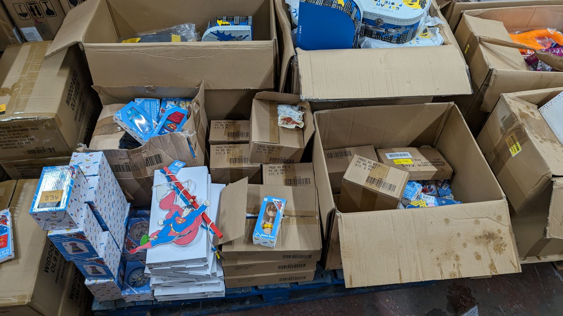 The contents of a pallet of Super Hero gifts including socks, hanging signs, alarm clocks, stacking