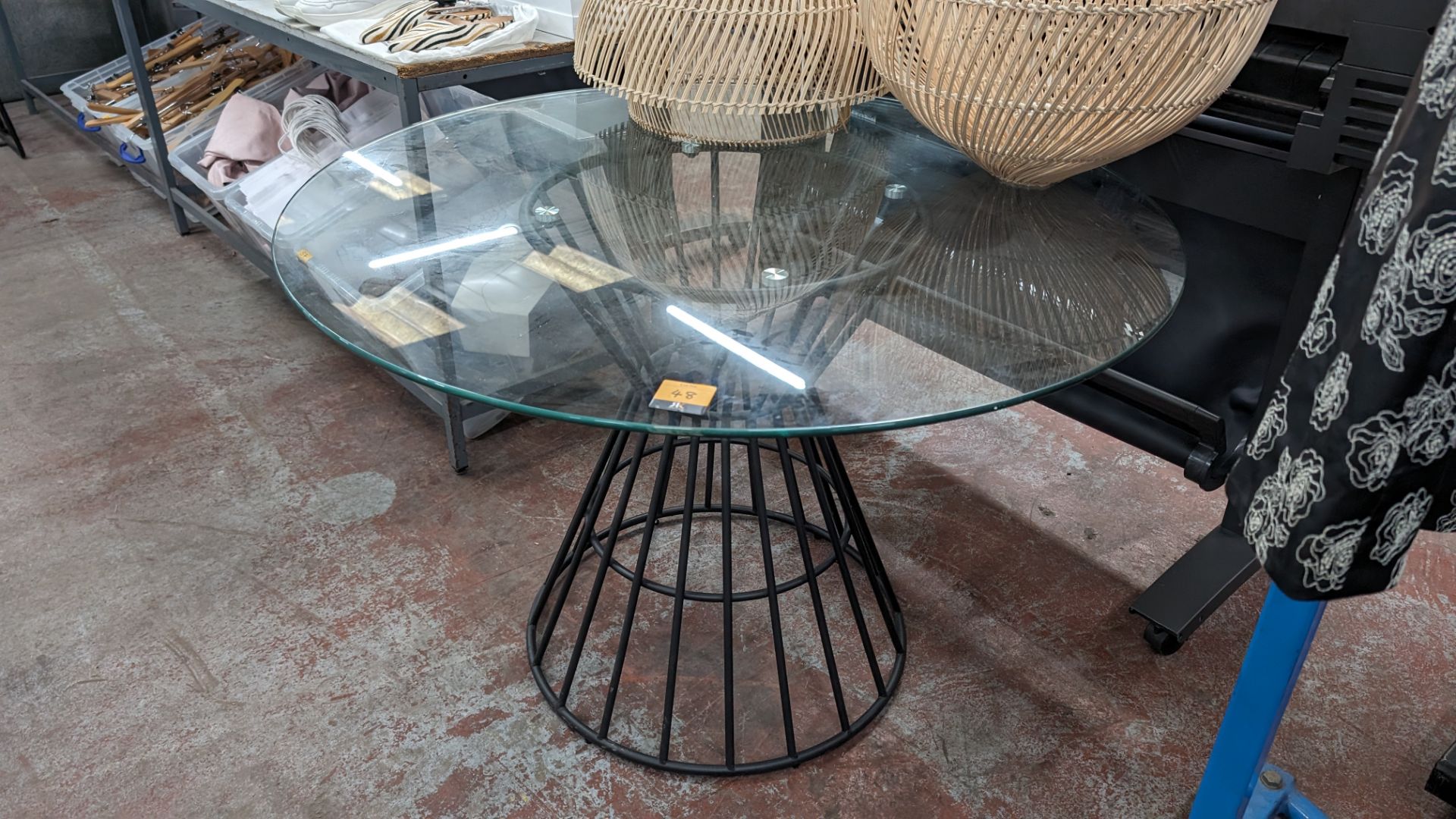 Large round glass table on black metal frame, table top approximately 1100mm diameter