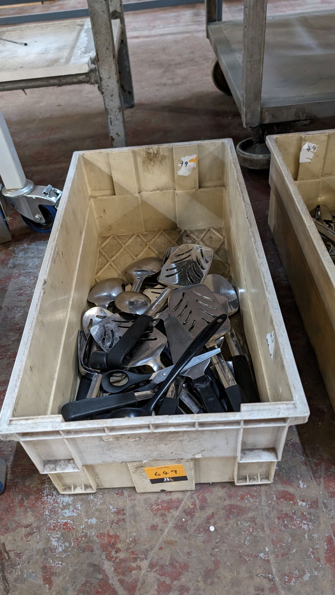 The contents of a crate of fish slices, cake slices, large spoons and similar