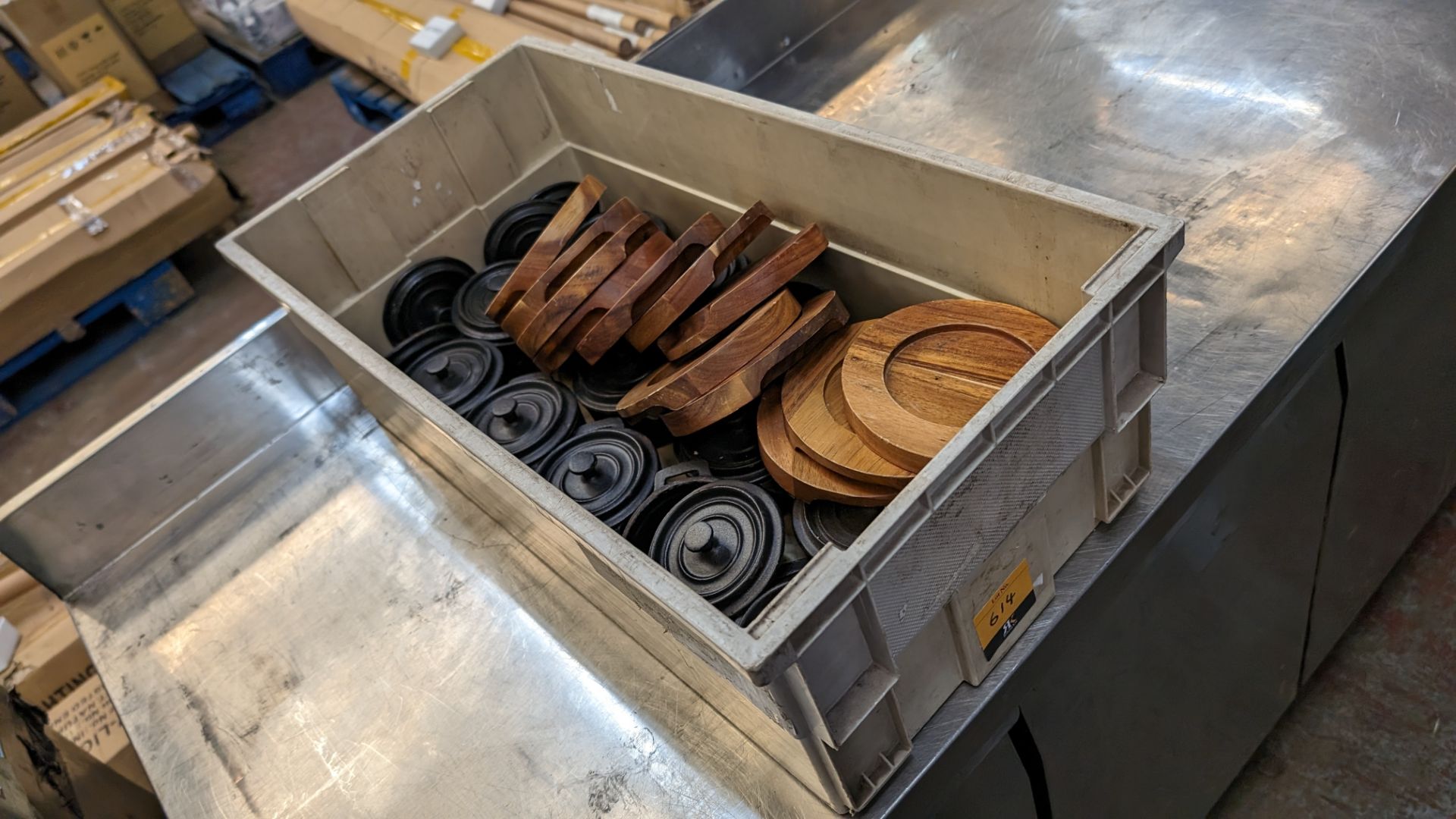 The contents of a crate of Utopia cast iron small pots with lids plus a quantity of wooden stands fo
