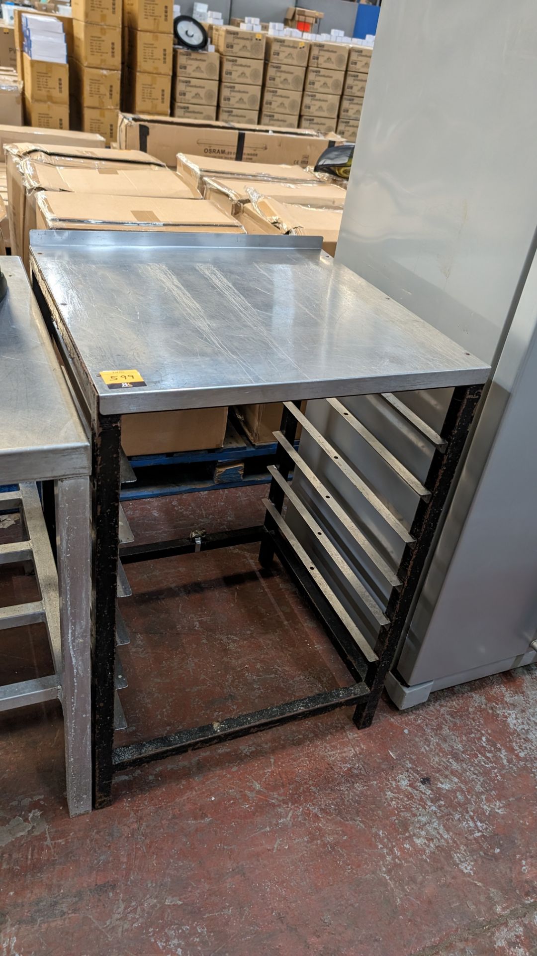 Stainless steel table with capacity for holding trays below, assumed to be for use for commercial di