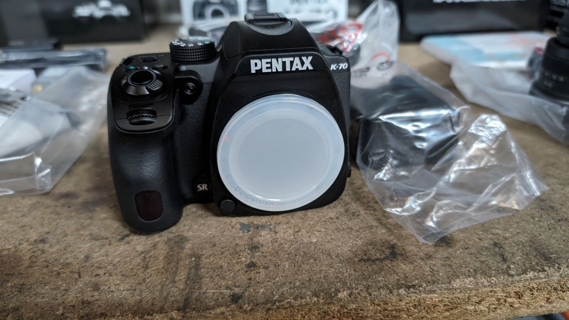 Pentax K-70 camera body, including strap, cable, battery and charger. NB: The box shows a lens, ho