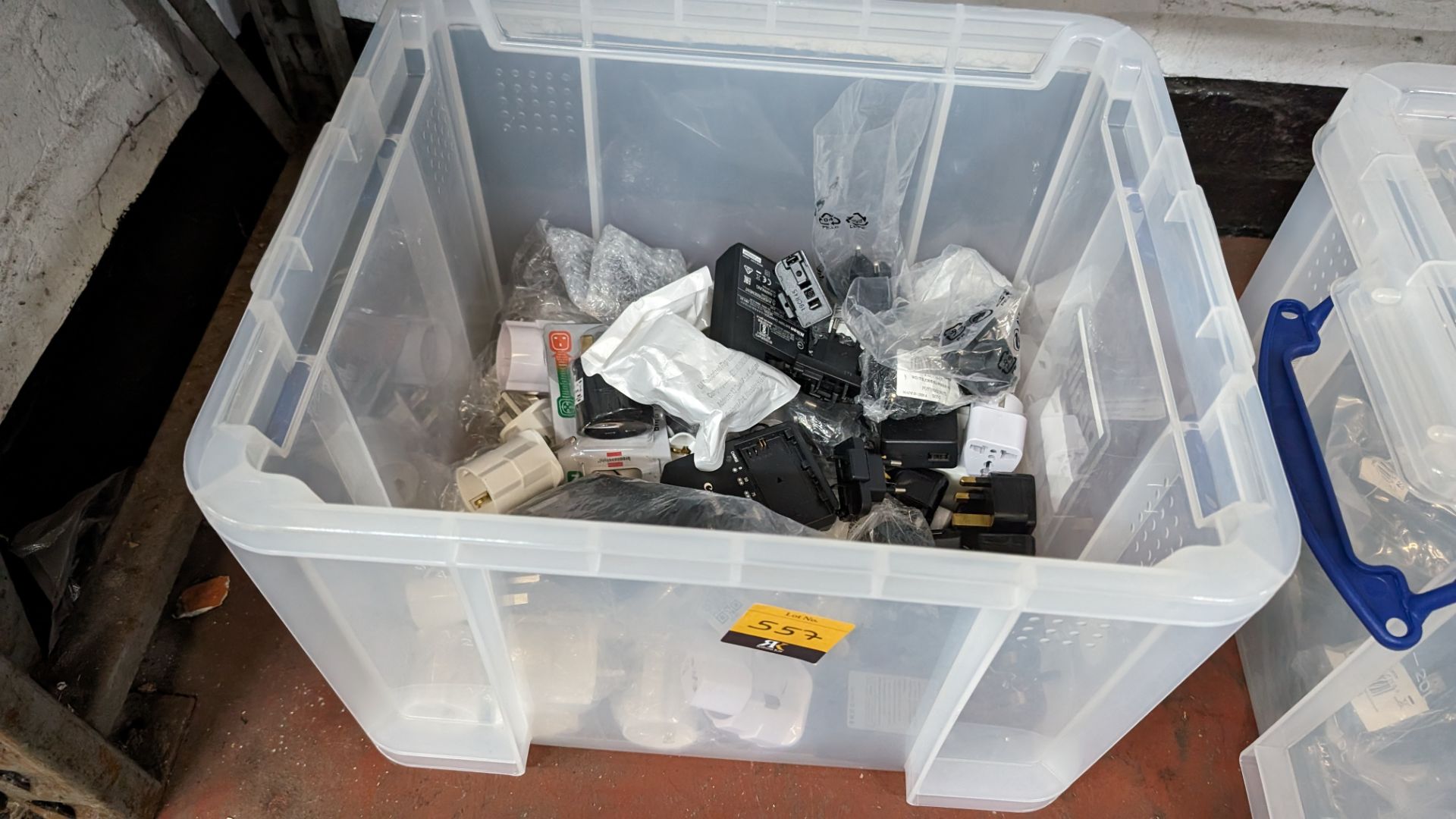 The contents of a crate of assorted power adaptors, battery charges and related