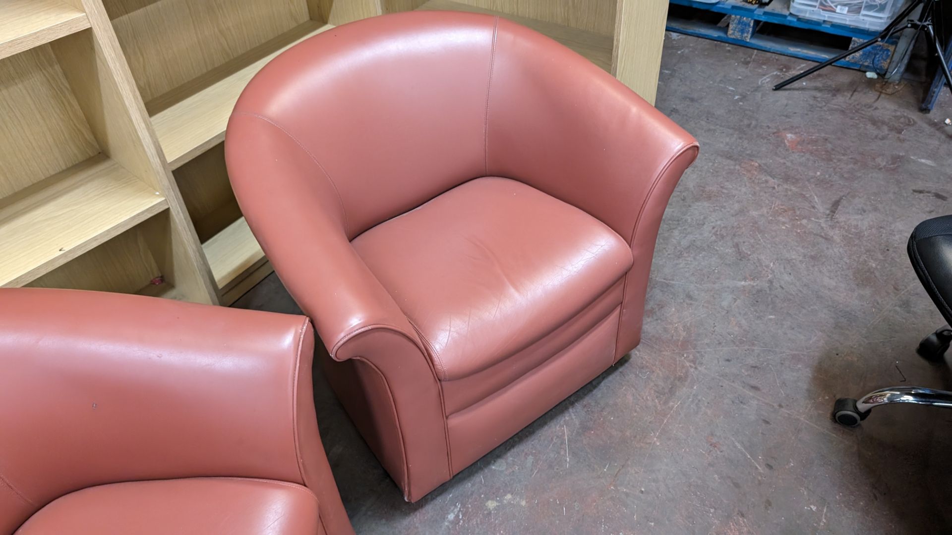 Pair of tub chairs on wheels in dark salmon/terracotta leather/pleather finish - Image 5 of 8