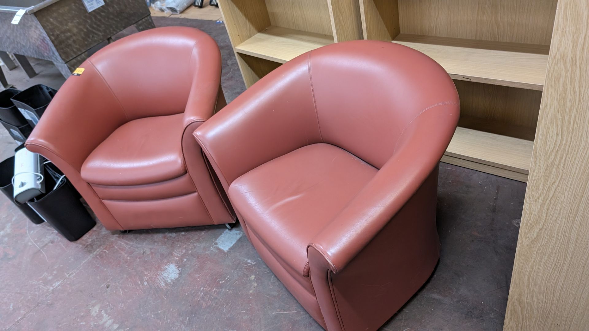 Pair of tub chairs on wheels in dark salmon/terracotta leather/pleather finish - Image 7 of 8