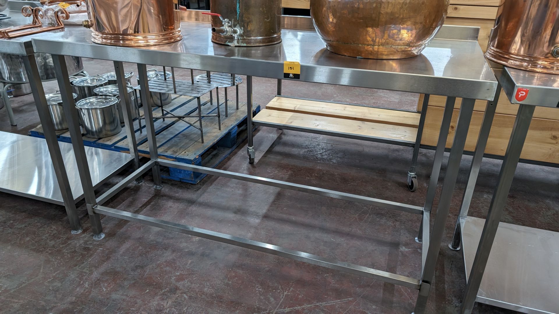 Stainless steel table with upstand at rear, max dimensions: 920mm x 600mm x 1300mm