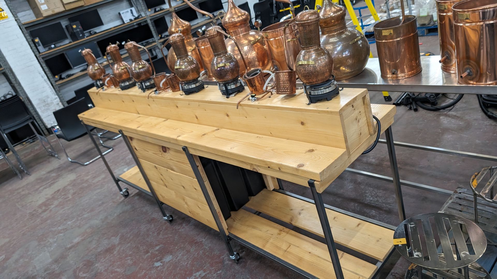 6 off small stills plus mobile bench. This lot comprises a custom made mobile bench with a metal fr