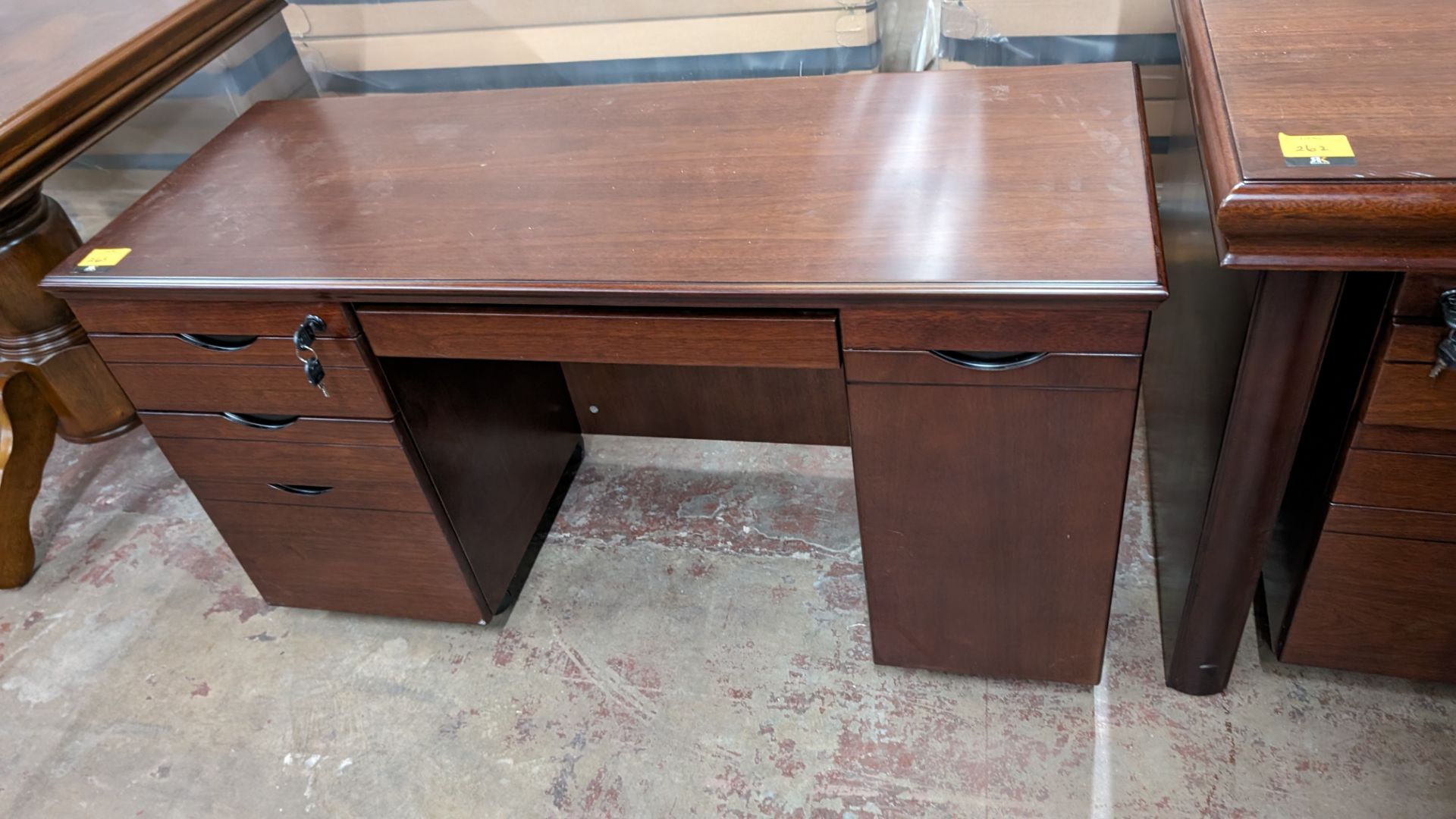 Small mahogany mobile desk with cupboard for computer to the right, drawer pack to the left and cent