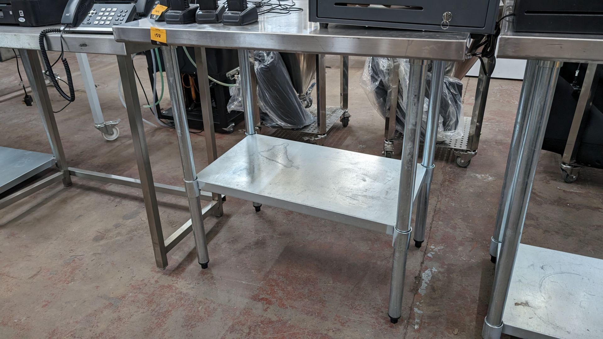 Stainless steel twin tier table with upstand at rear, max dimensions: 940mm x 610mm x 915mm
