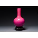 A Chinese monochrome ruby-pink-glazed 'tianqiuping' vase on wooden stand, Yongzheng mark, 19/20th C.