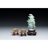 A pair of Chinese jade sculptures of elephants and a lidded vase on wooden stands, 19th C.