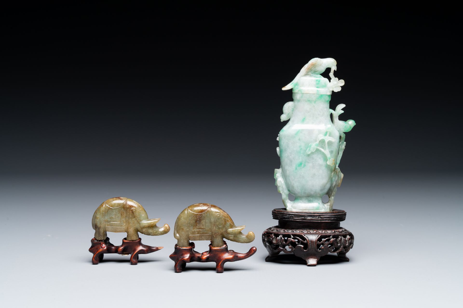 A pair of Chinese jade sculptures of elephants and a lidded vase on wooden stands, 19th C. - Image 3 of 5