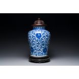 A Chinese blue and white 'lotus scroll' jar with wooden cover and stand, Kangxi