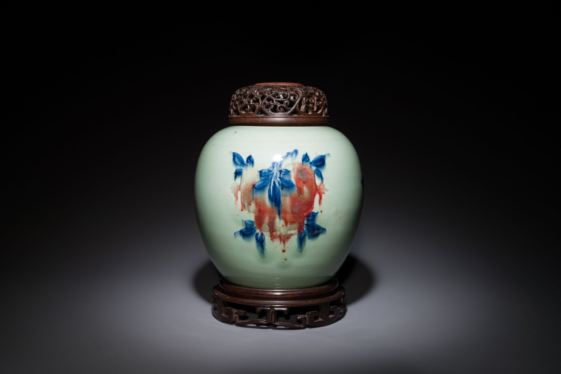 A Chinese celadon-ground blue, white and copper-red ginger jar with wooden cover and stand, 18th C.
