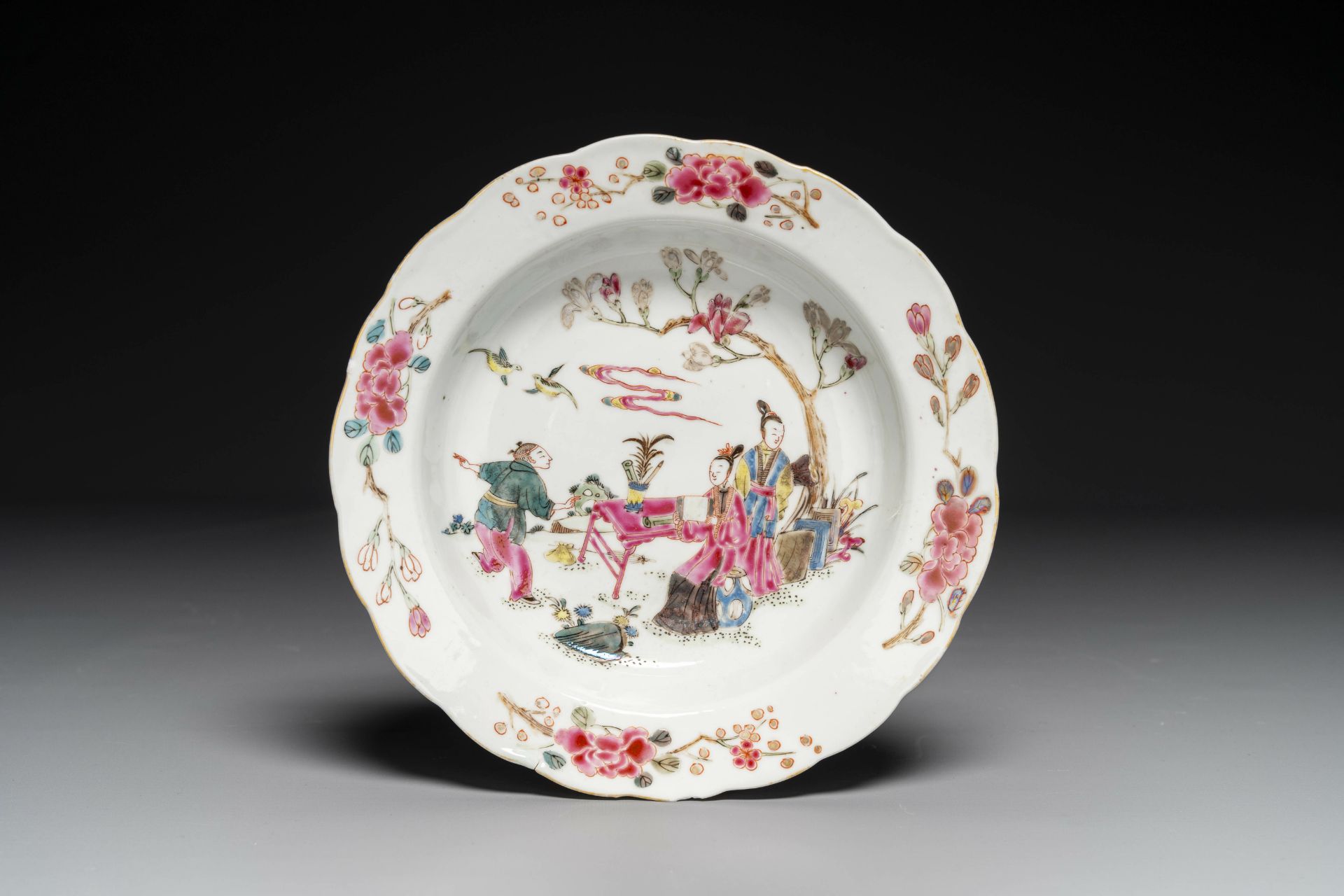 A Chinese famille rose plate with figures in a garden, Yongzheng