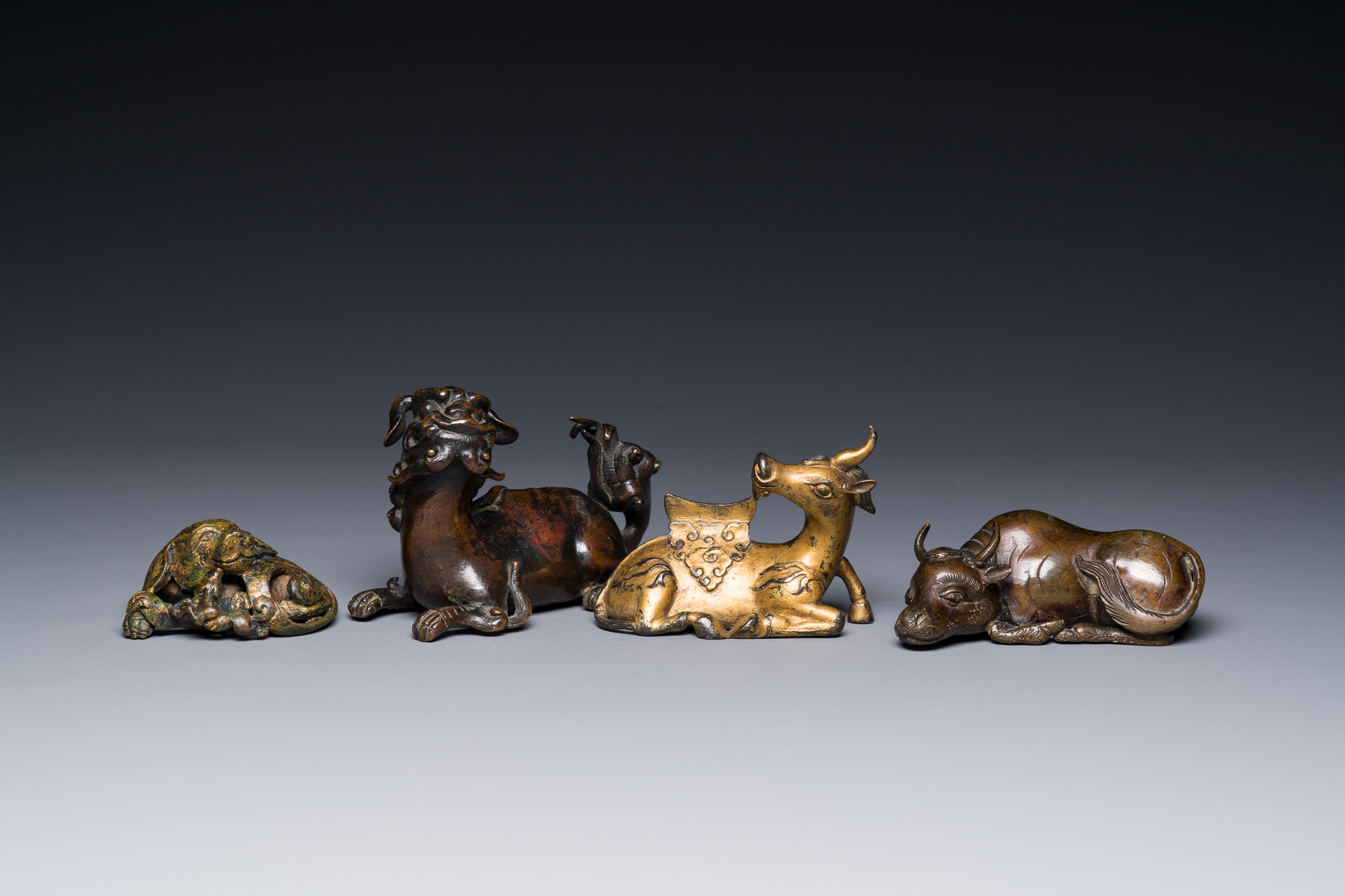 A group of four Chinese gilt bronze paper-weights, Ming/Qing