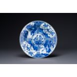 A Chinese blue and white dish with landscape and floral panels, Kangxi