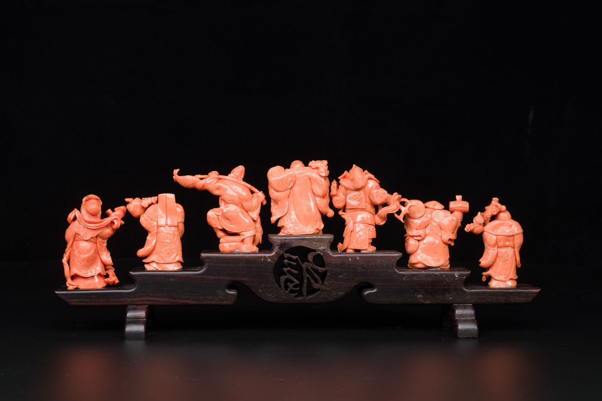 A set of seven Chinese red coral figures on wooden stand, 19/20th C. - Image 2 of 3