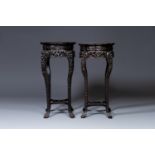 A pair of tall Chinese carved wooden stands with marble tops, 19th C.