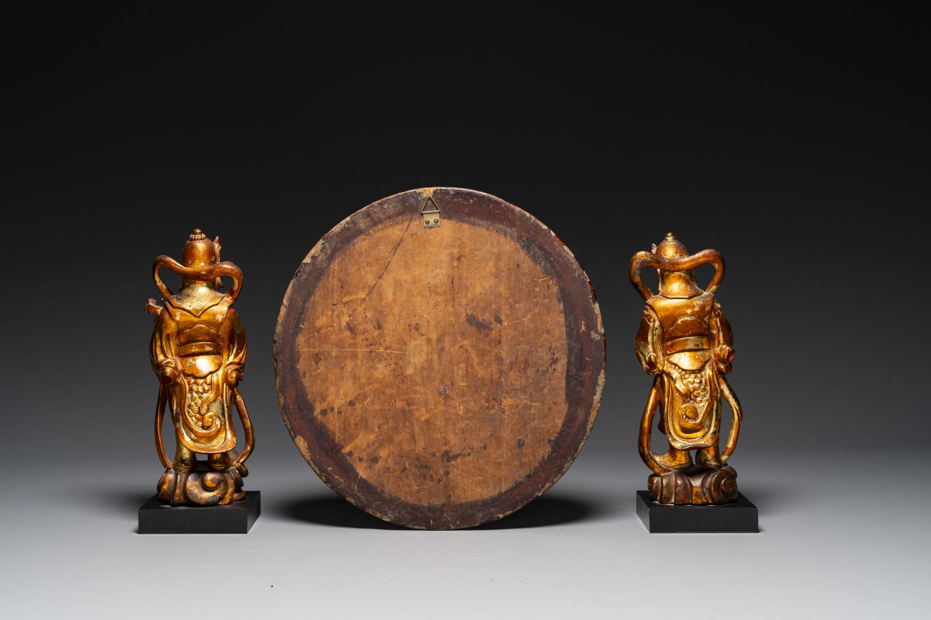 A pair of Chinese gilt-lacquered wooden guardians and a round 'dragon' plaque, 19th C. - Image 3 of 6