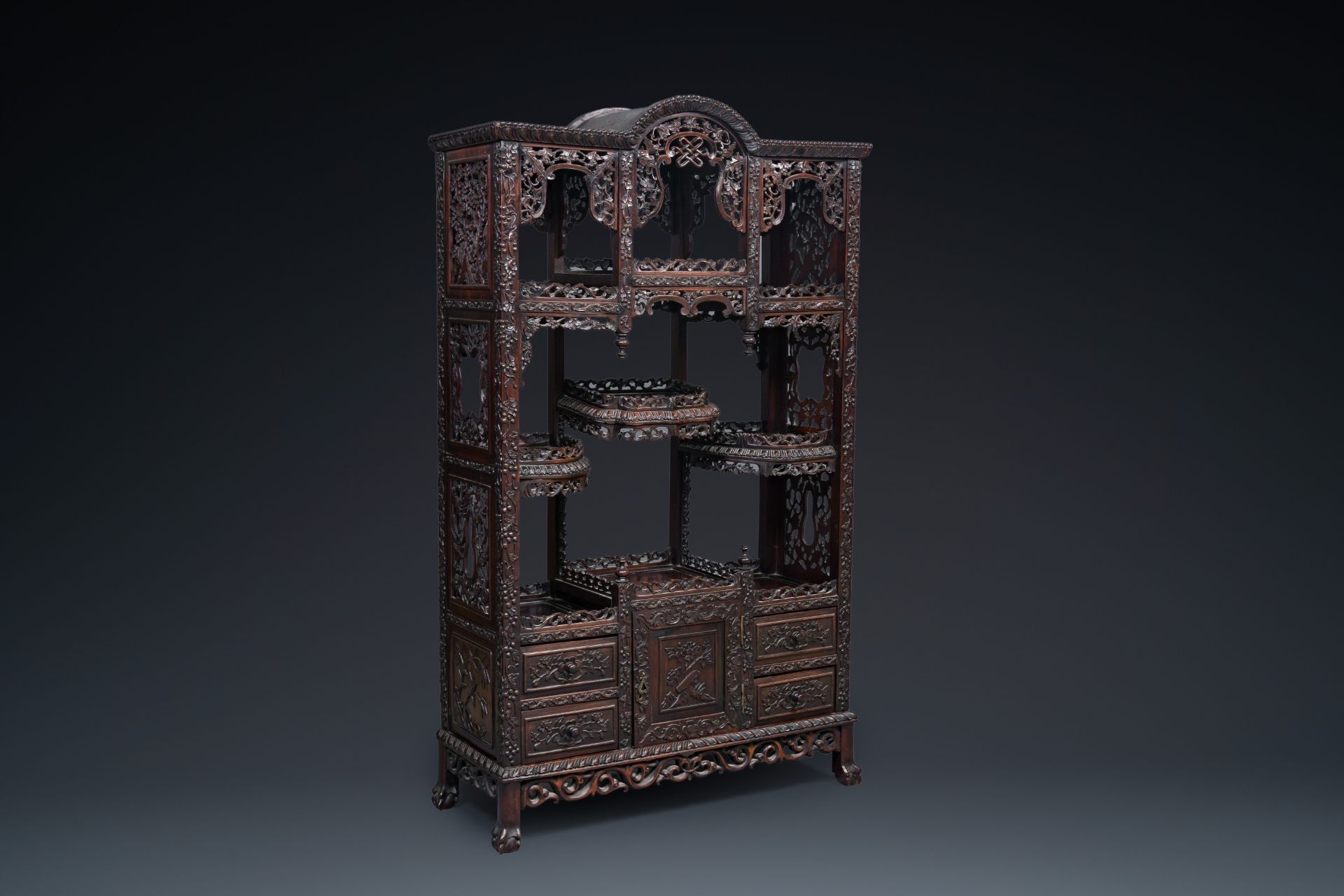 A richly carved Chinese hongmu wooden etagere cupboard, Canton, 19th C.