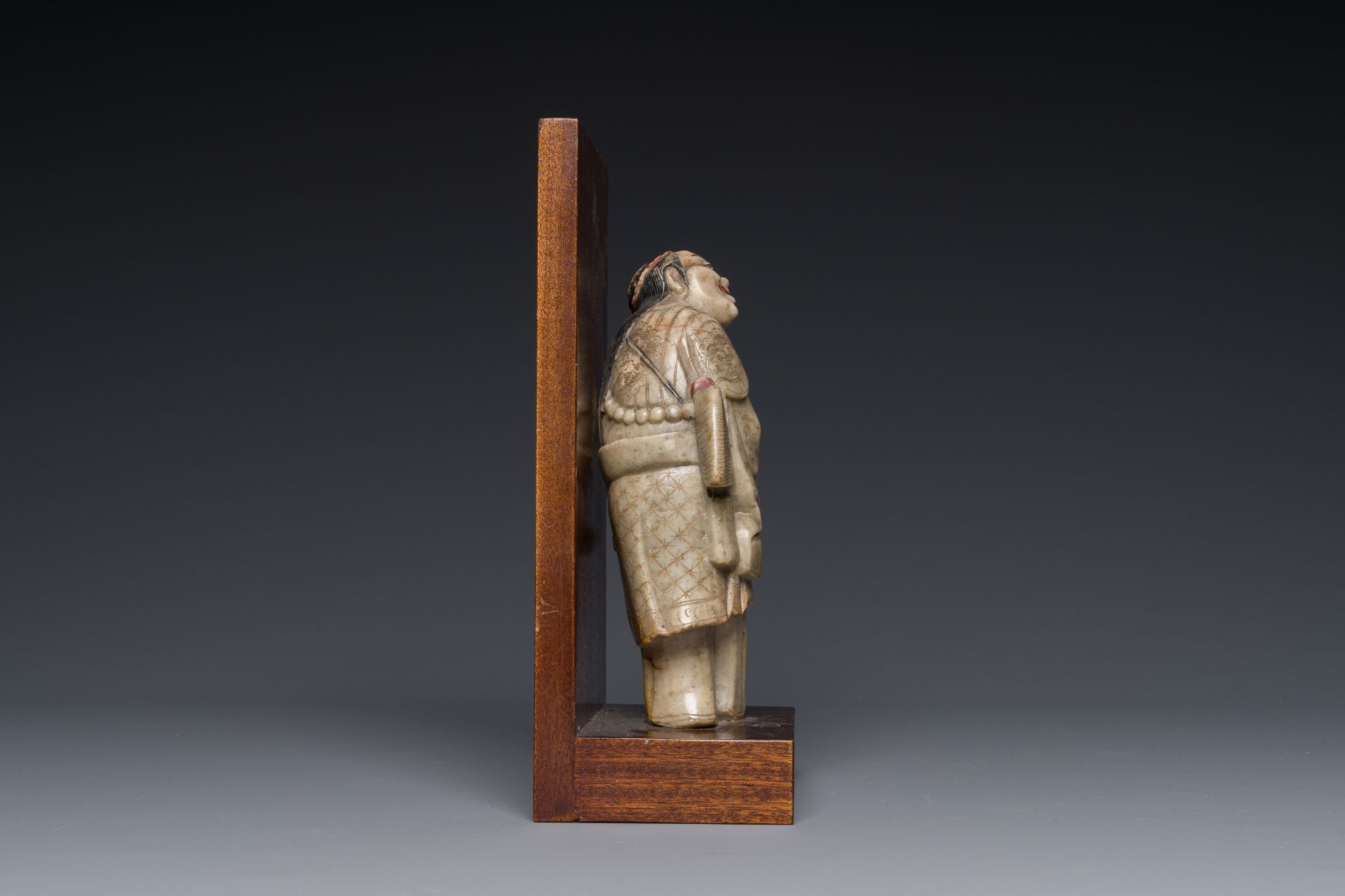 A Chinese partly polychromed soapstone figure on a wooden base, 18th C. - Bild 3 aus 4