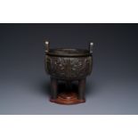 A Chinese archaistic bronze tripod censer on wooden stand, 'ding', Song/Ming