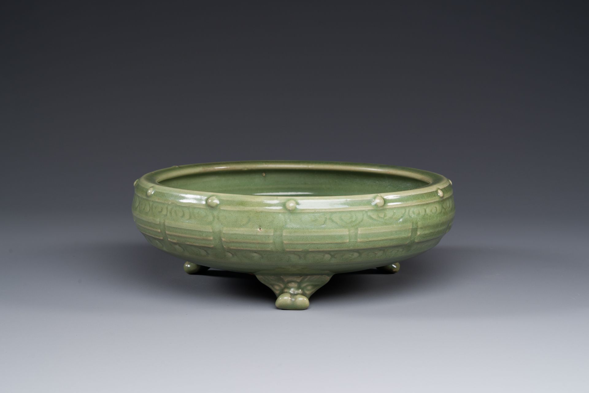 A Chinese Longquan celadon tripod censer on wooden stand, Yuan/Ming