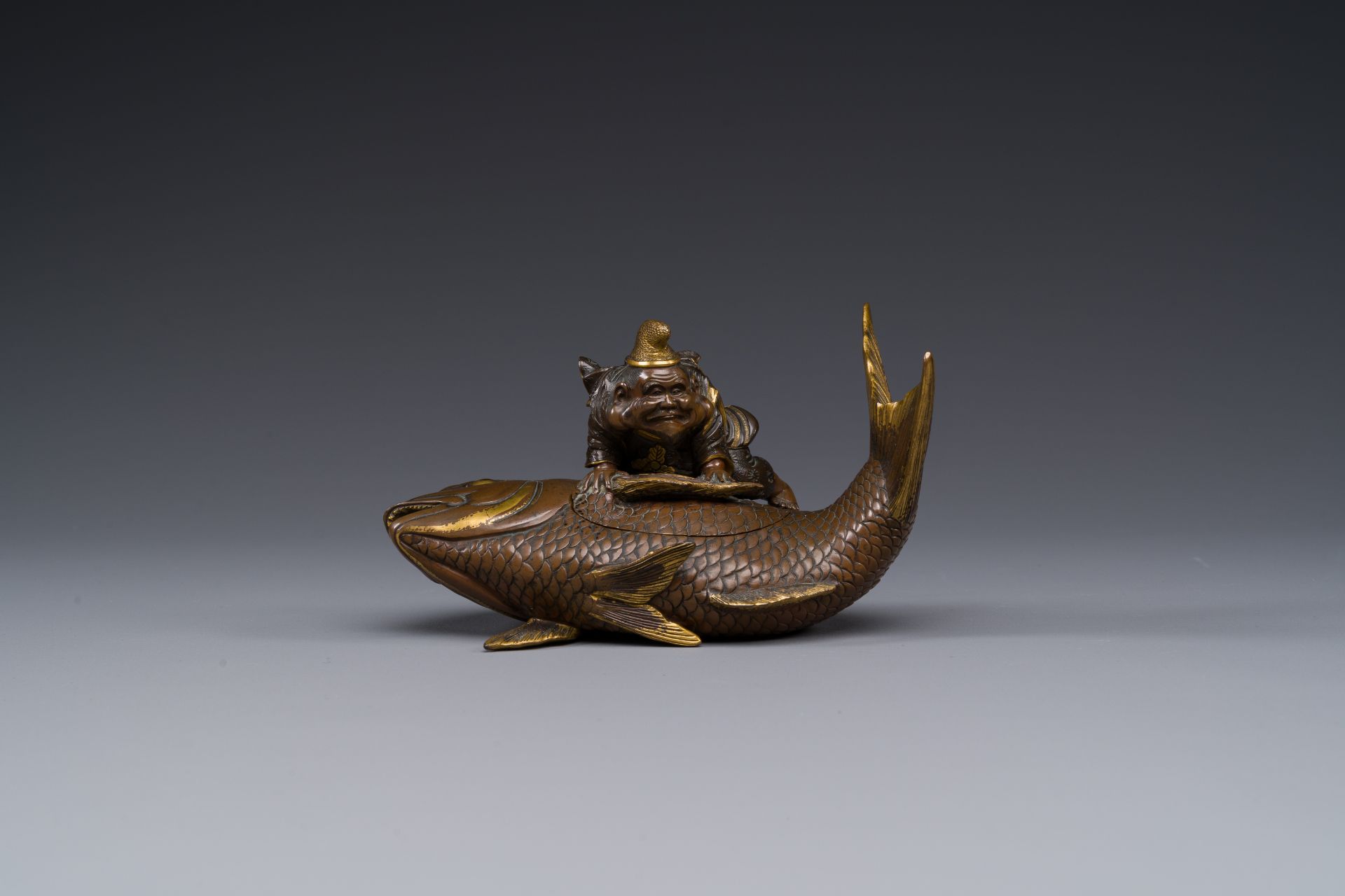 A Japanese partly gilded bronze lidded box in the shape of Ebisu on sea bream, signed Miyao Zo, Meij