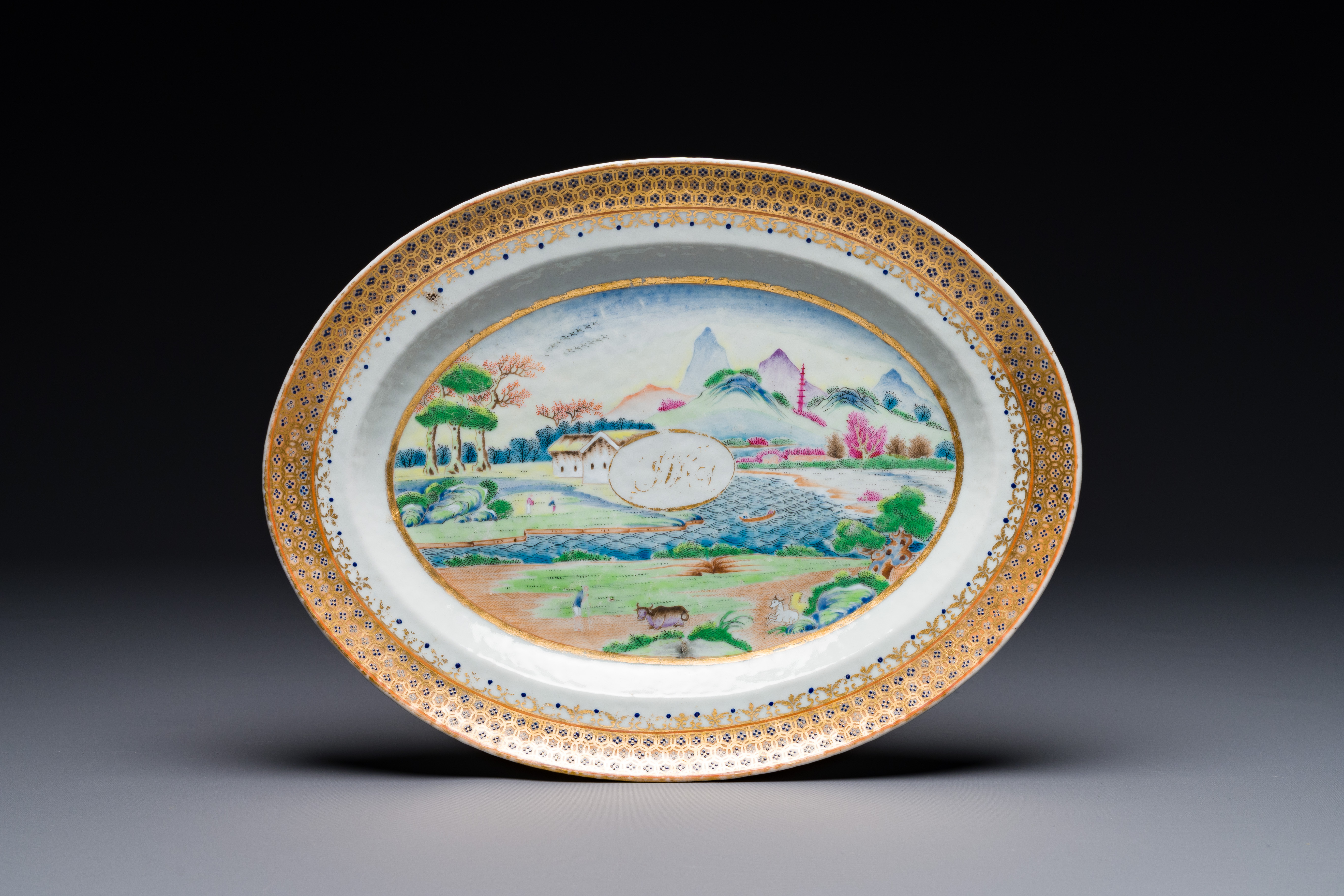 An oval Chinese monogrammed Canton famille rose dish with landscape design, 19th C.