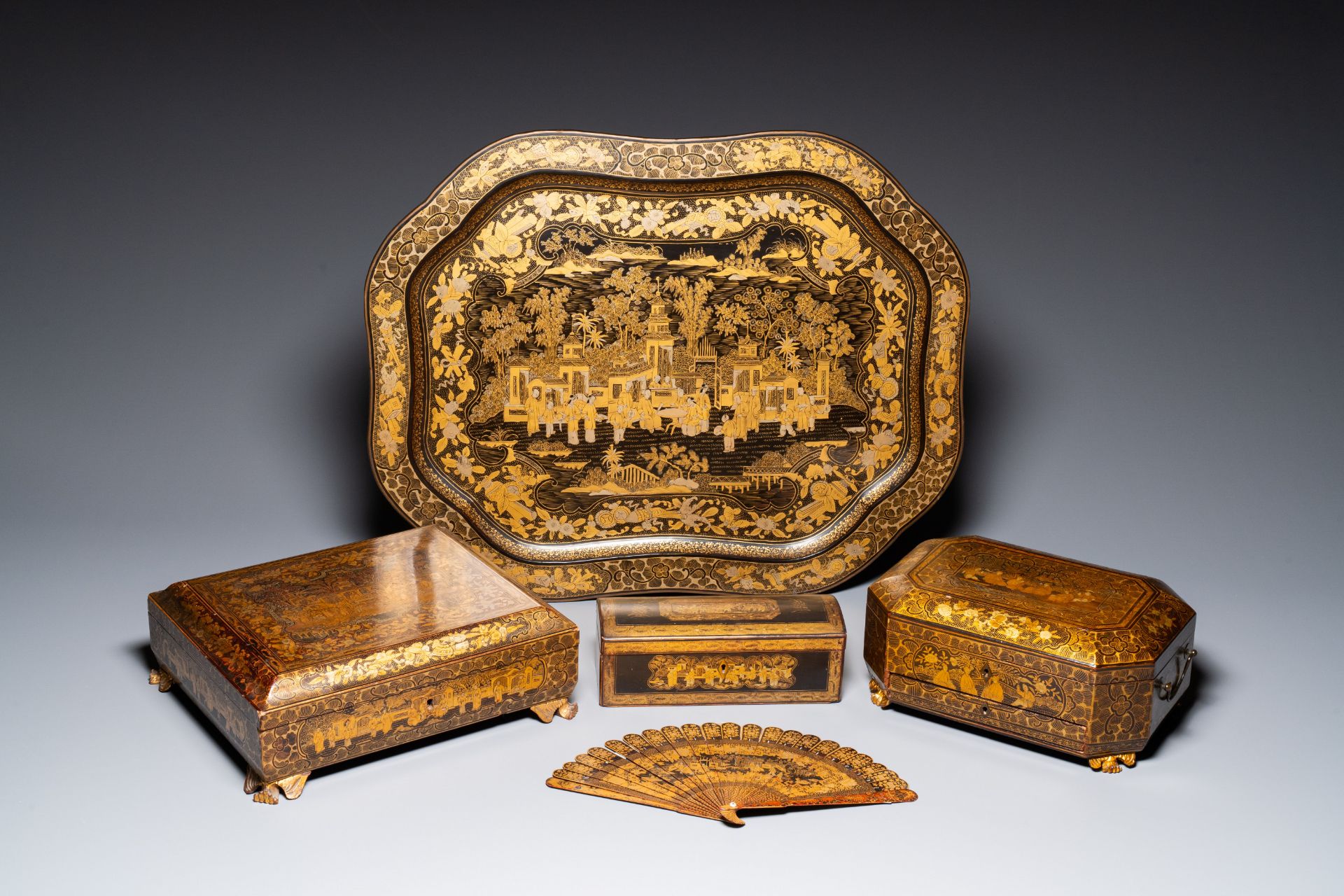 A large Chinese Canton gilt black lacquer tray, thee boxes and a fan, 19th C.