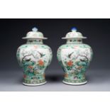 A pair of Chinese famille verte 'bird and flower' vases and covers, Kangxi mark, 19th C.