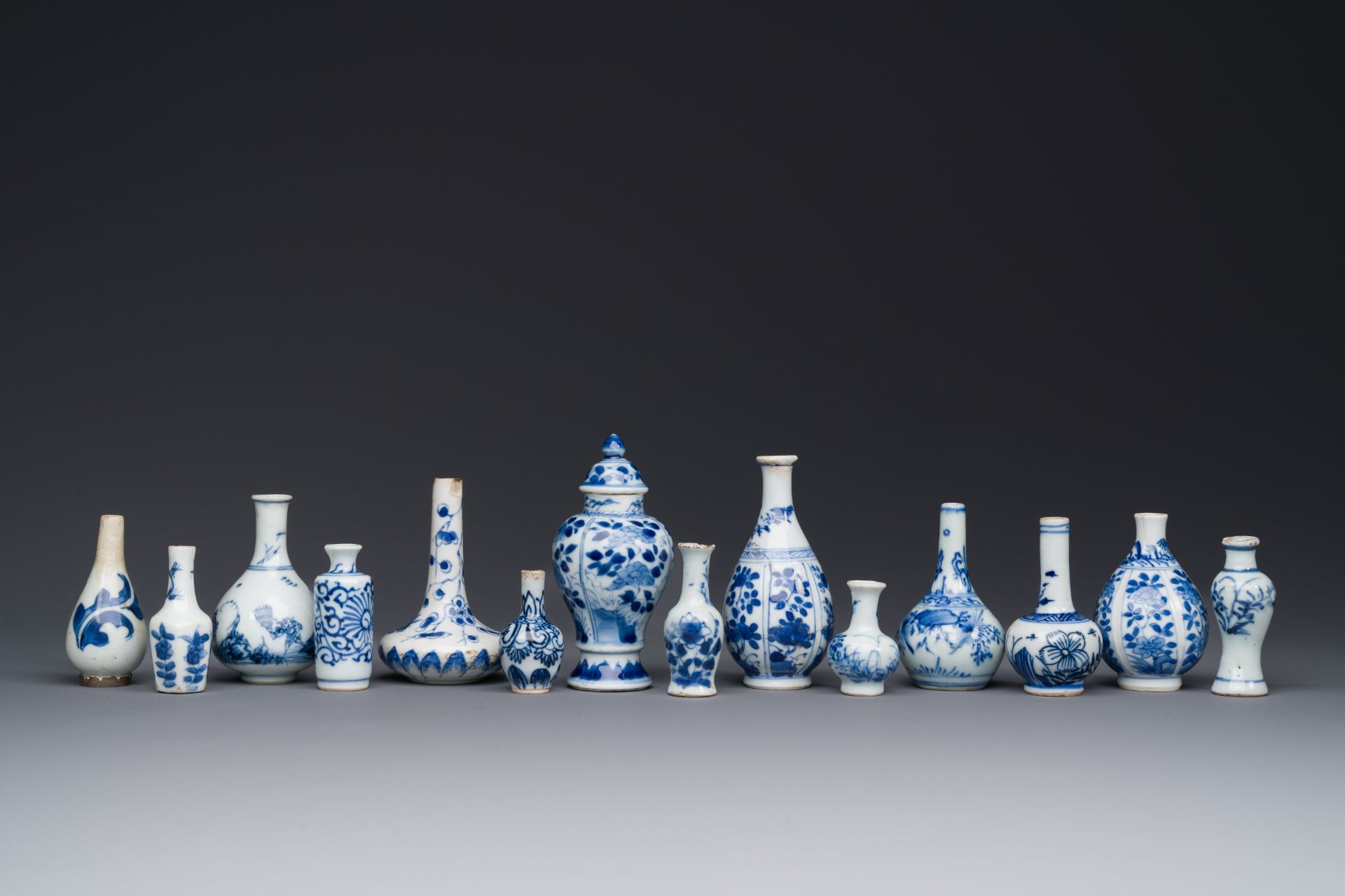 Fourteen Chinese blue and white miniature vases with floral design, Kangxi