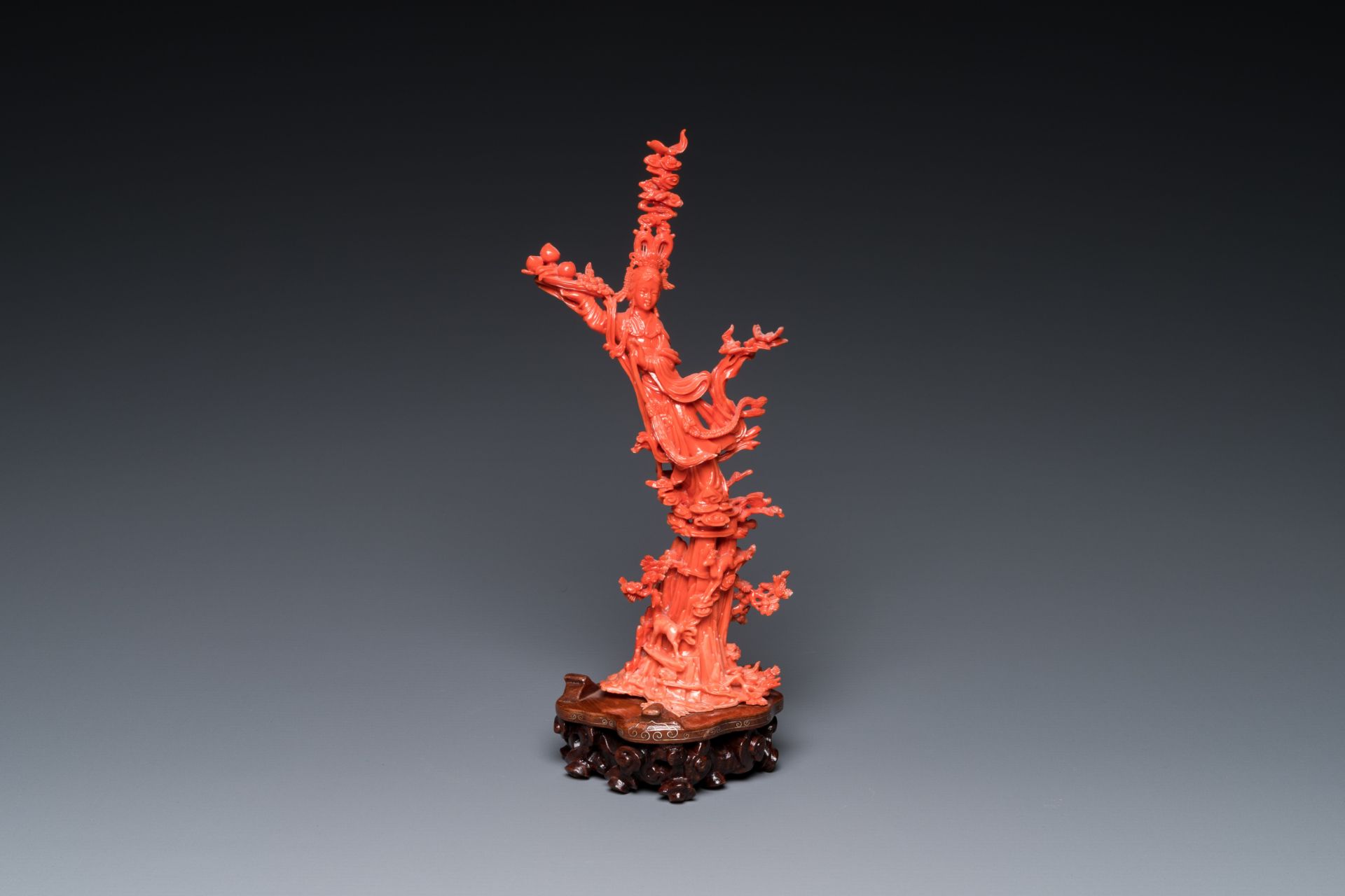 A Chinese red coral sculpture of Xiwangmu standing on a rock, 19/20th C.