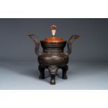 An important Chinese bronze tripod 'taotie' censer with wooden lid, Ming