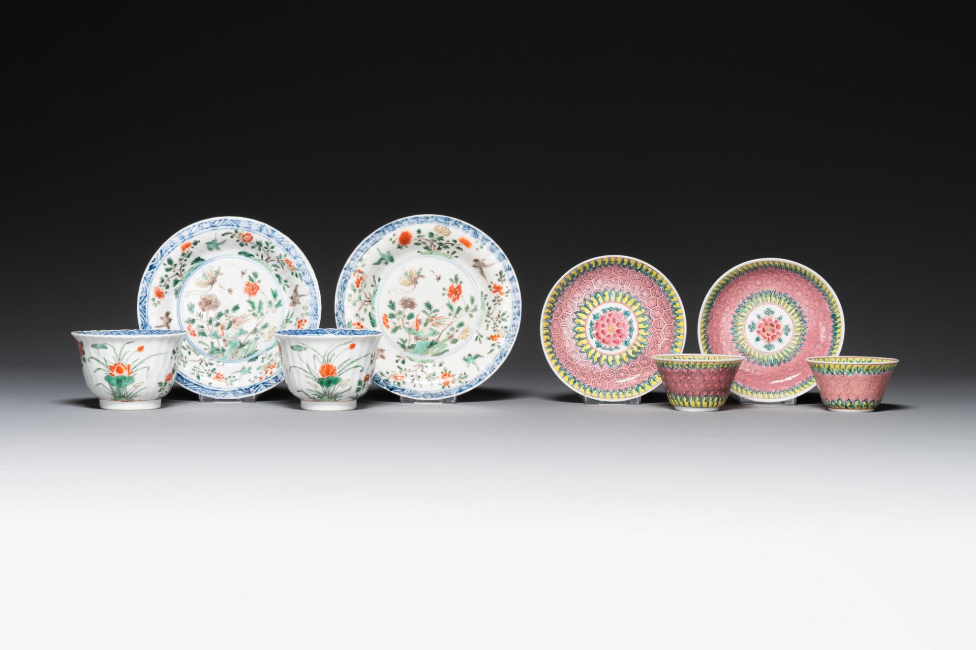 A pair of Chinese famille verte and a pair of famille rose cups and saucers, Kangxi/Yongzheng