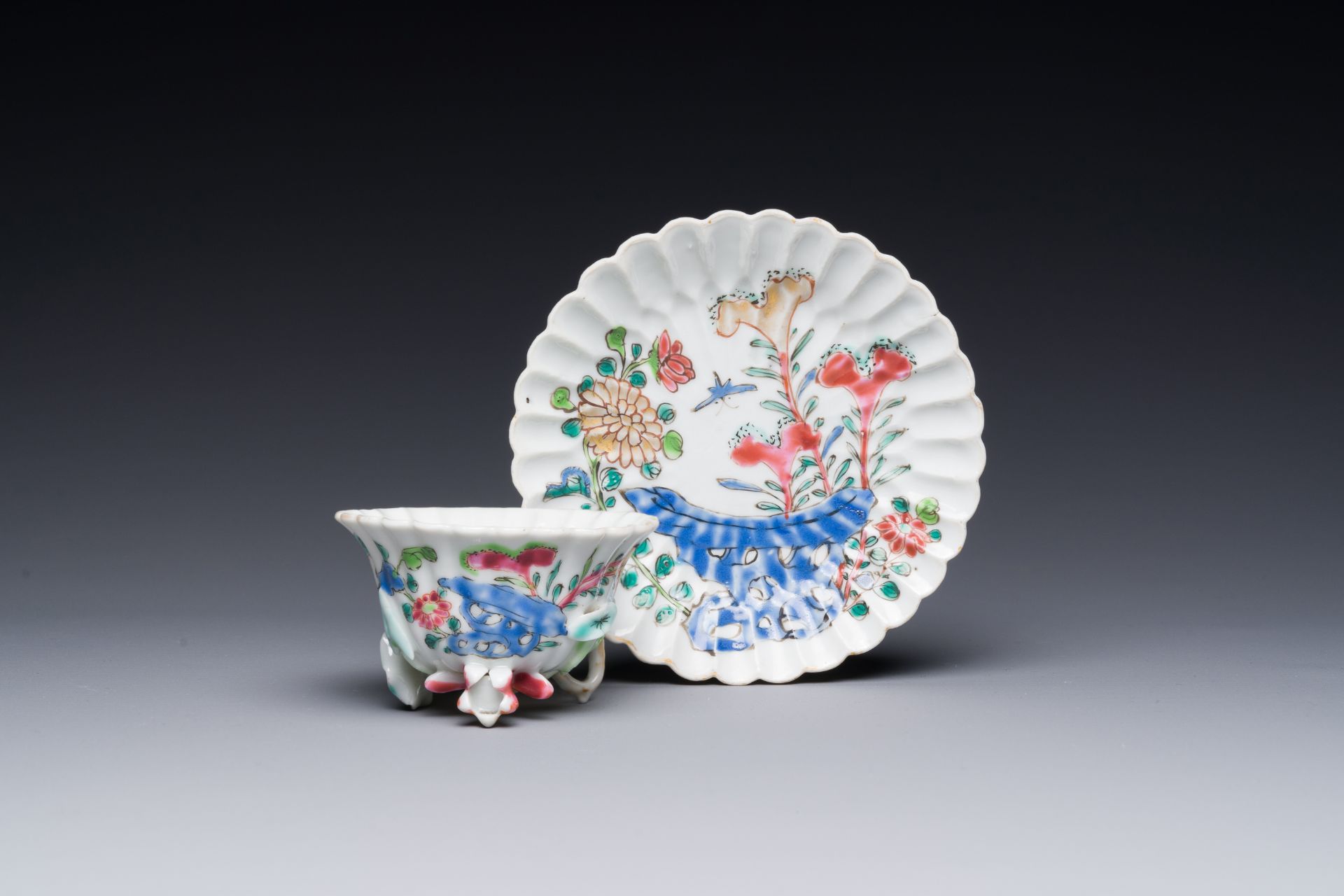 A Chinese famille rose relief-decorated cup and saucer, Yongzheng