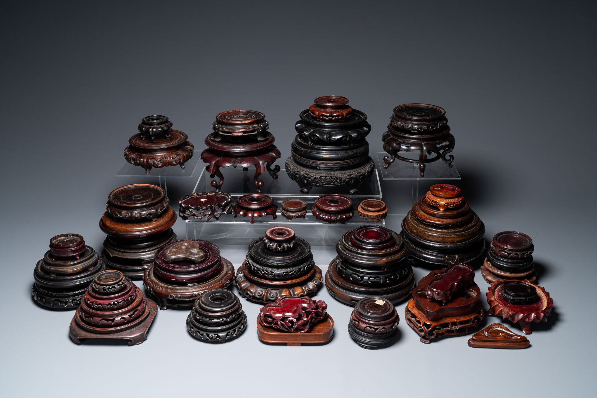 A large collection of 58 varied Chinese wooden stands, 19/20th C.