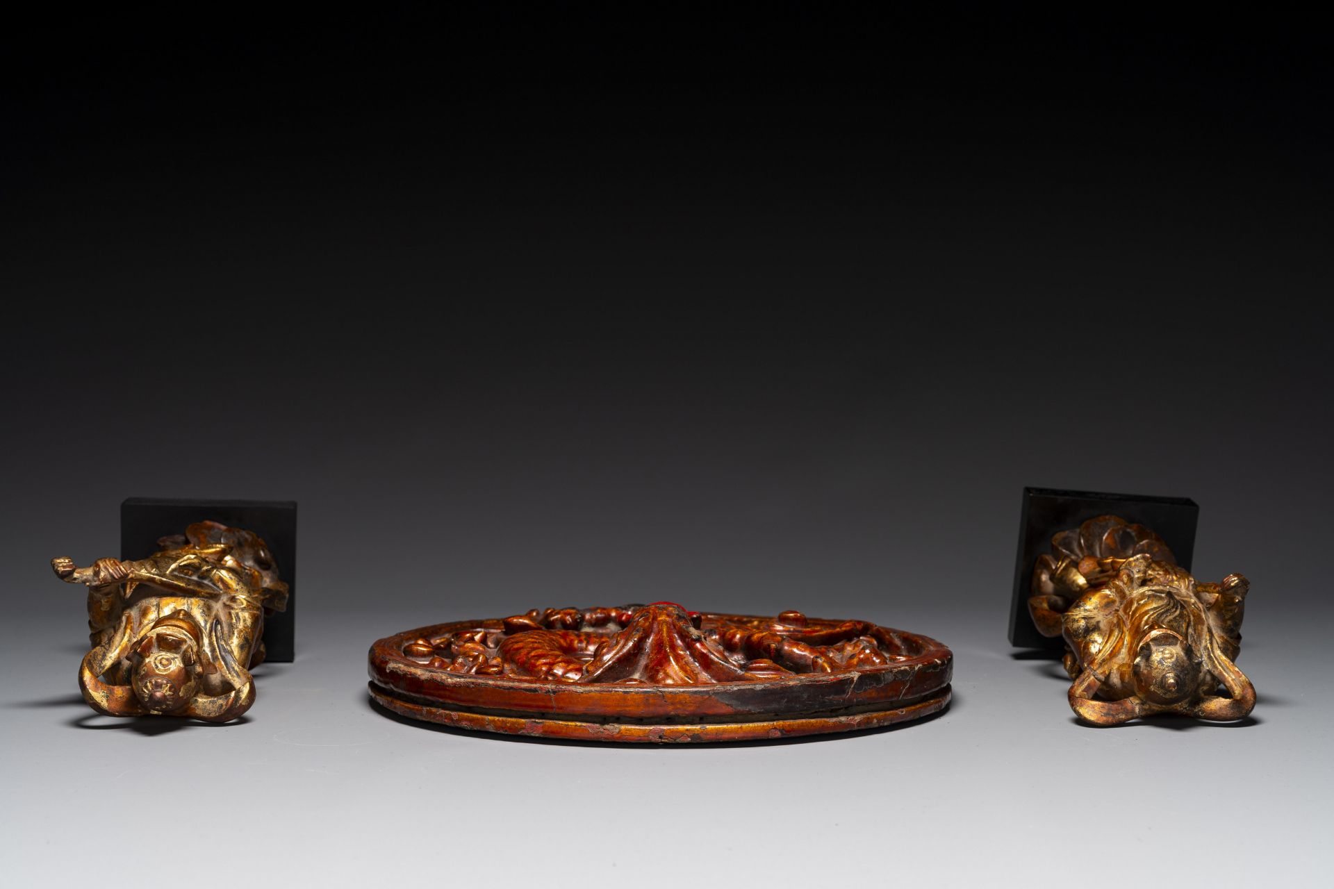 A pair of Chinese gilt-lacquered wooden guardians and a round 'dragon' plaque, 19th C. - Image 5 of 6