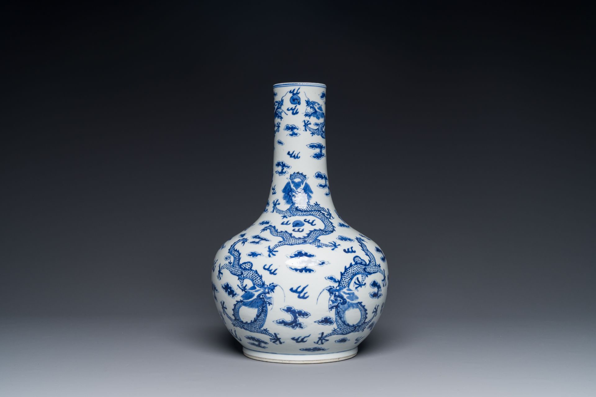 A Chinese blue and white bottle vase with dragons among flames and clouds, 19th C.