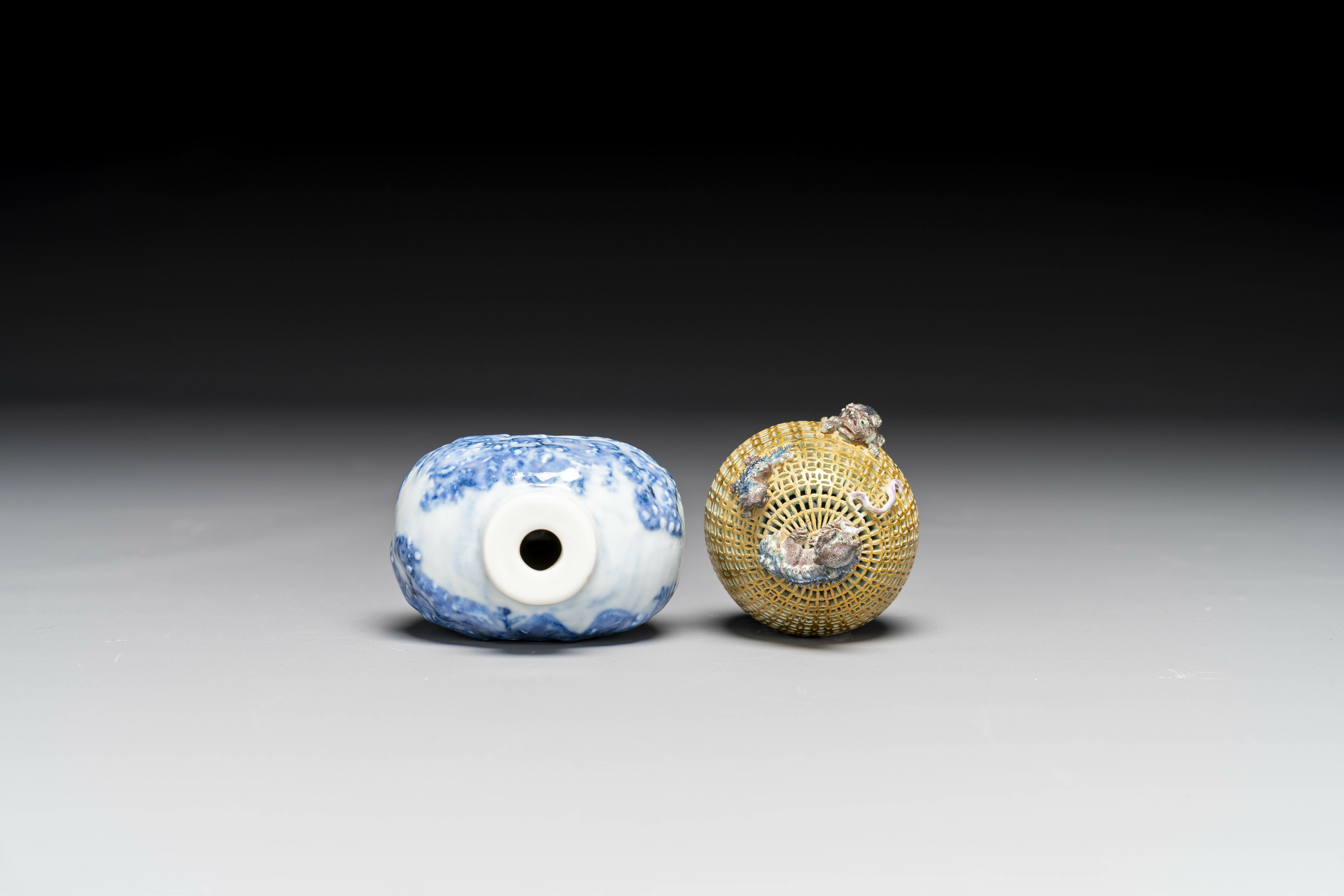 A Chinese blue and white snuff bottle and a famille rose openworked ball, 19th C. - Image 6 of 7