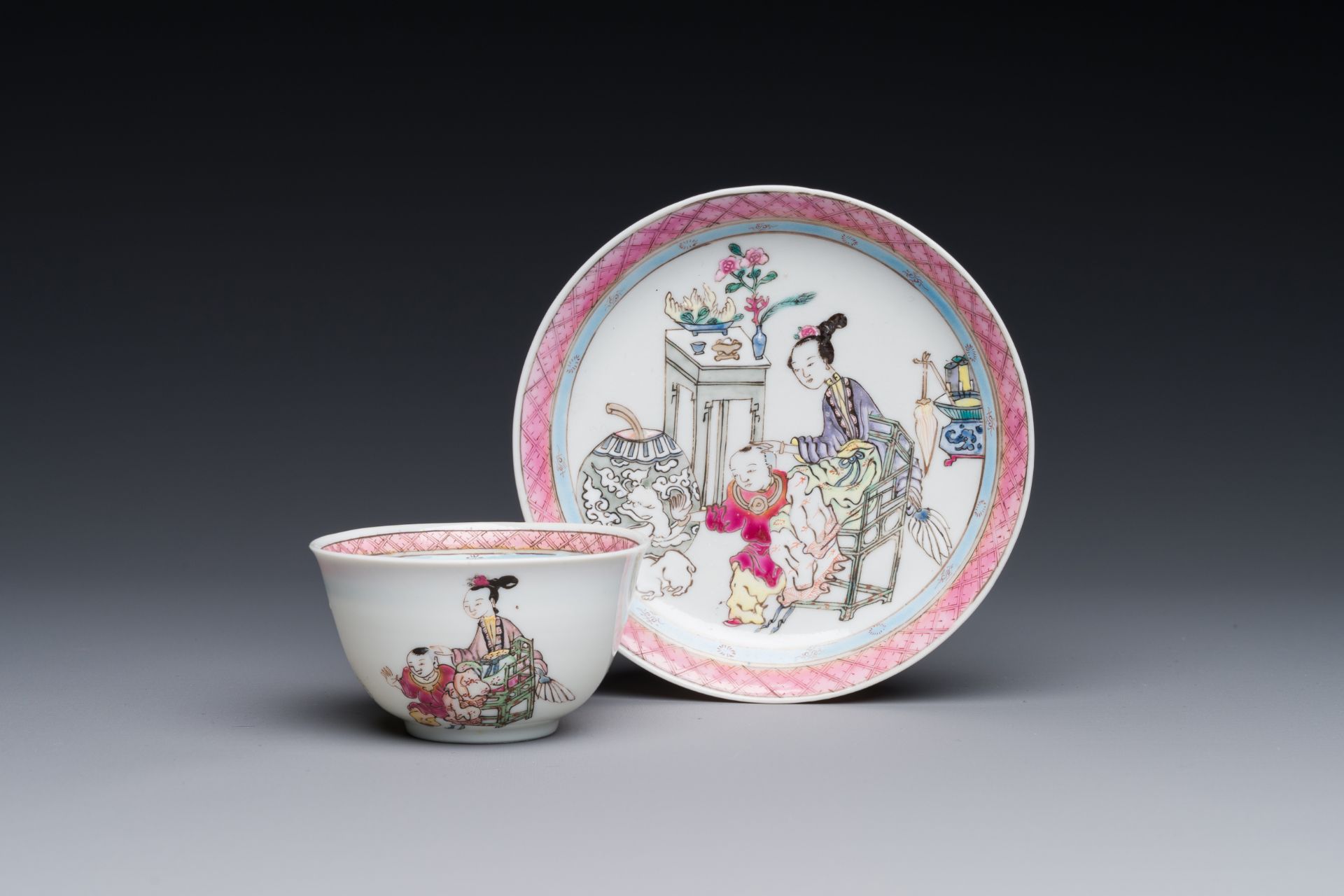 A Chinese famille rose cup and saucer with a court lady and a boy, Yongzheng