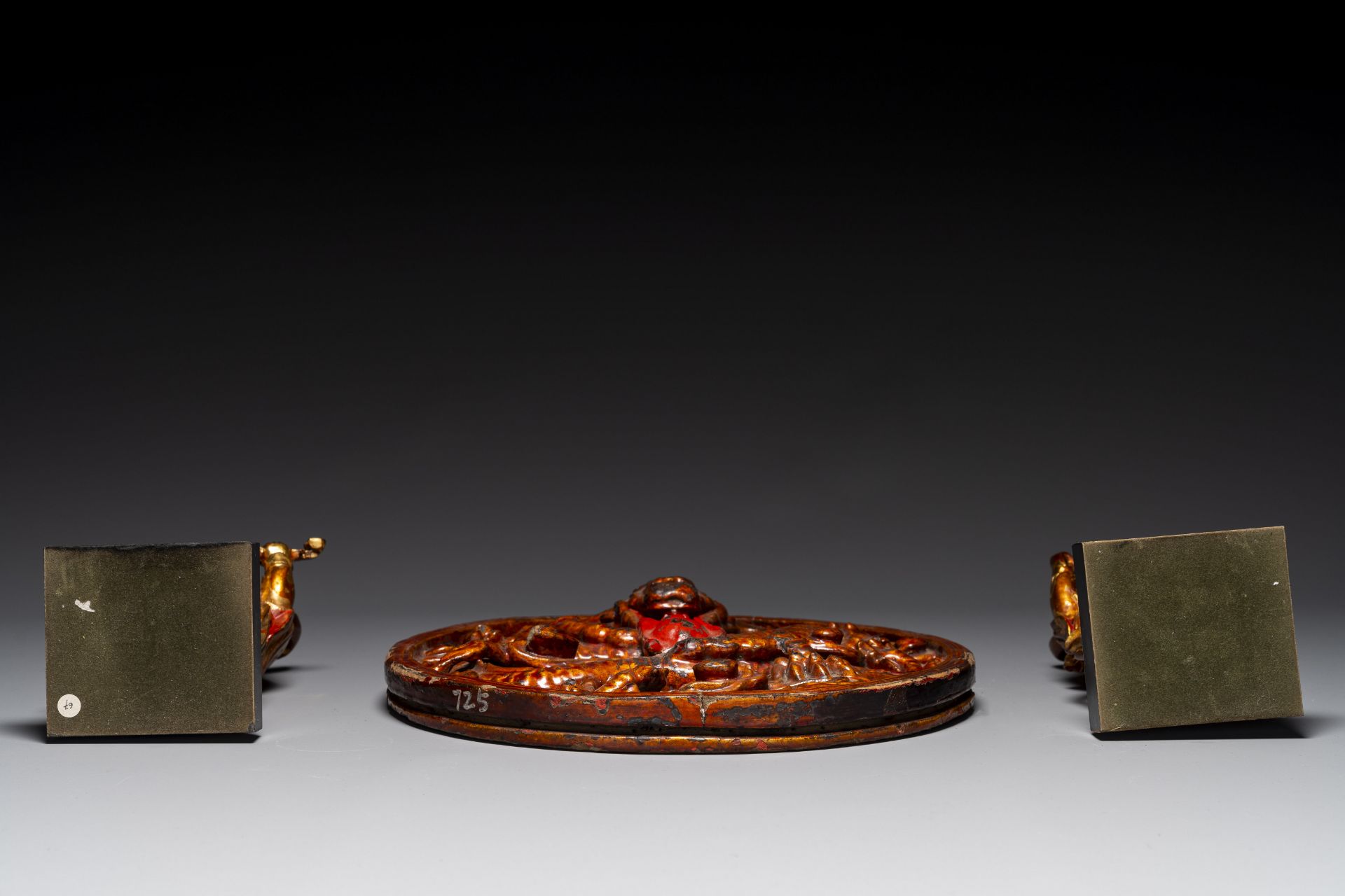 A pair of Chinese gilt-lacquered wooden guardians and a round 'dragon' plaque, 19th C. - Image 6 of 6