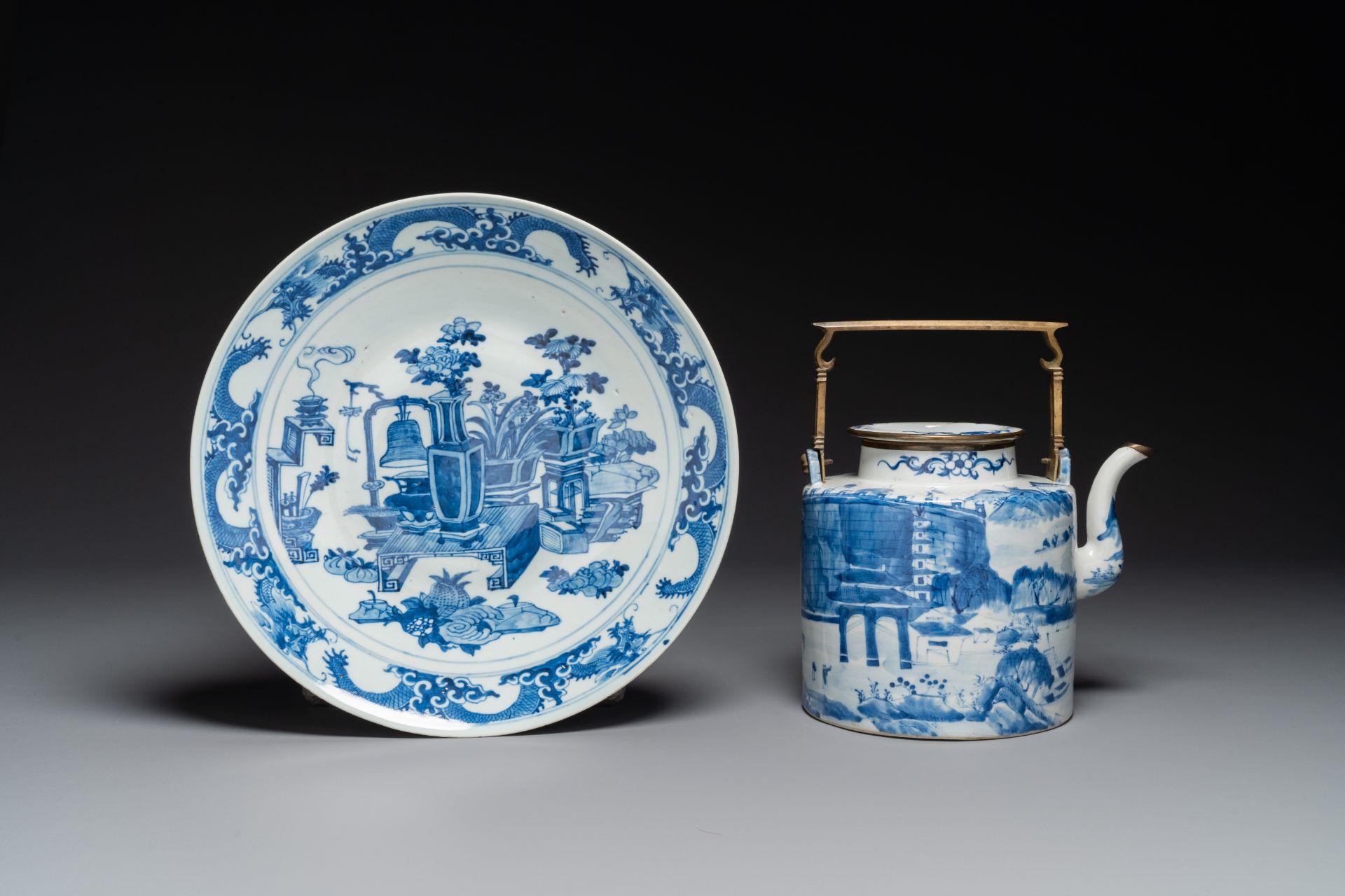 A Chinese blue and white teapot with landscape design and an 'antiquities' dish, 19th C.