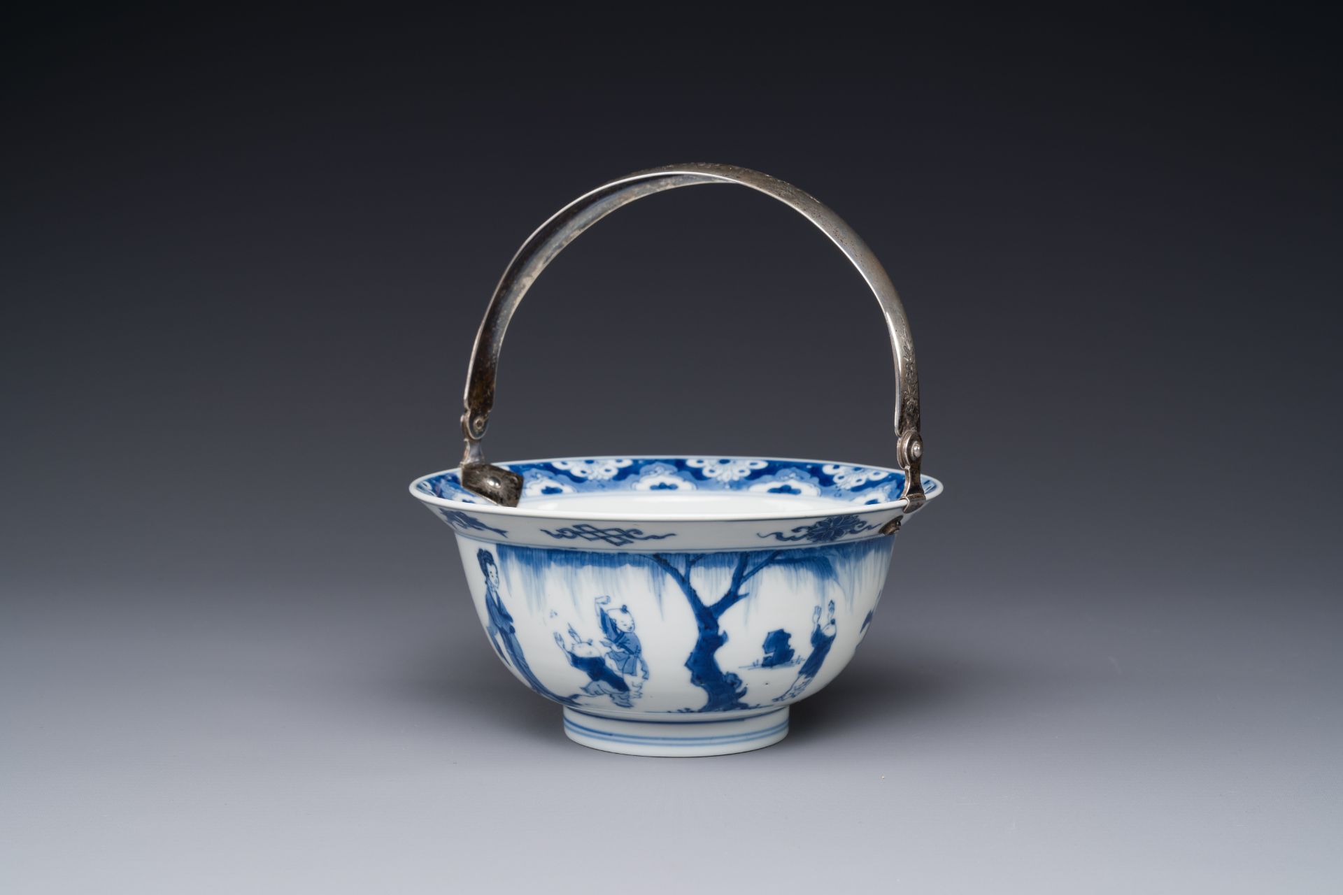 A Chinese blue and white bowl depicting playing boys and ladies with a silver handle, Chenghua mark,