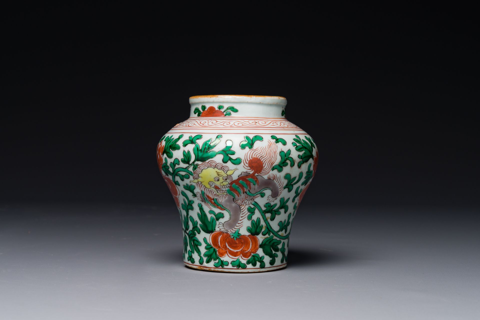 A small Chinese wucai 'Buddhist lion and peony scroll' jar, Transition period