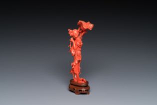 A Chinese red coral figure of a standing lady holding a flower, 19/20th C.