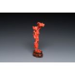 A Chinese red coral figure of a standing lady holding a flower, 19/20th C.