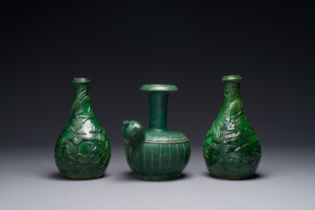 Two Chinese monochrome green-glazed stoneware 'dragon' vases and a kendi, Fujian kiln, late Ming