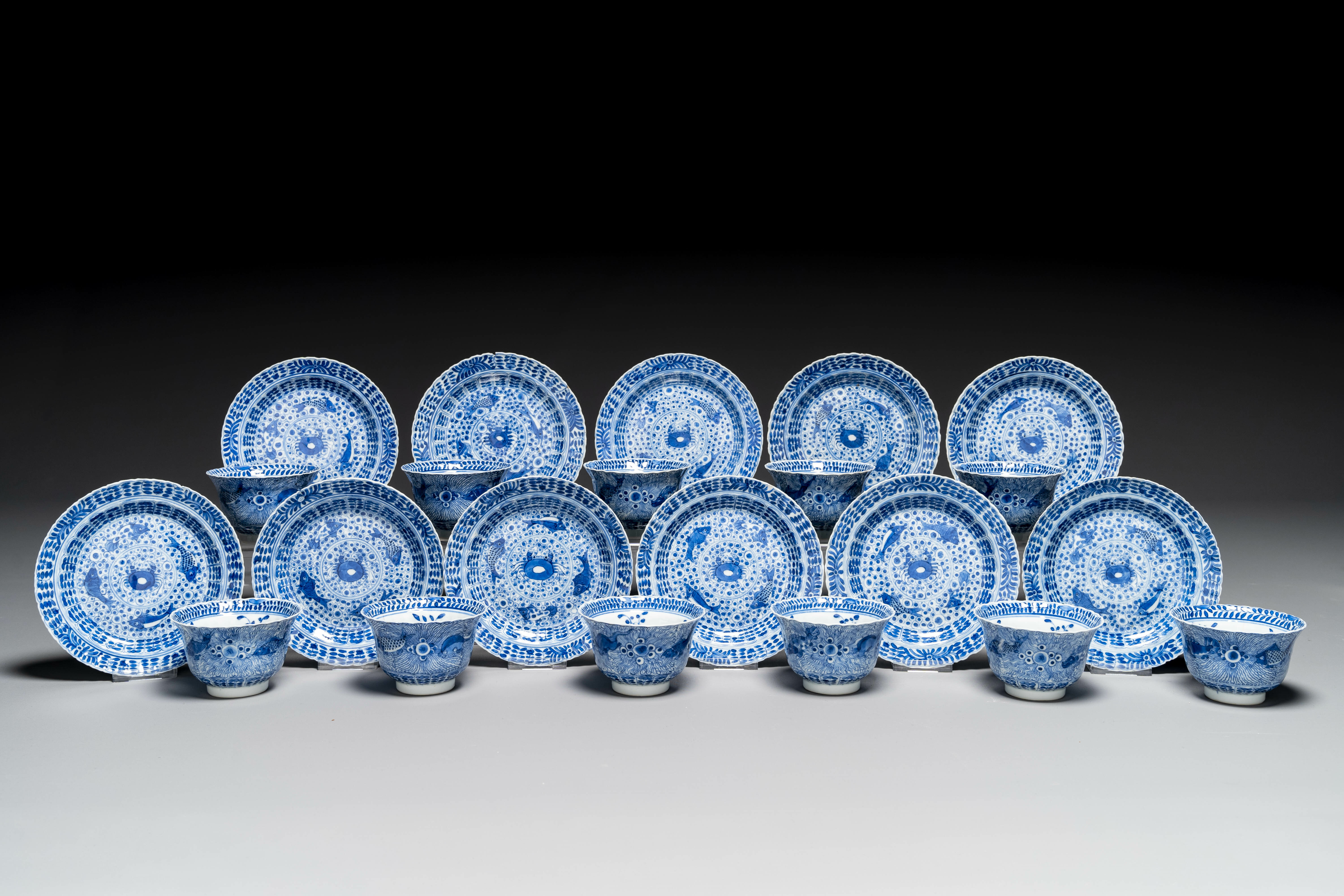 Eleven Chinese blue and white 'crab and fish' cups and saucers, Kangxi mark, Guangxu